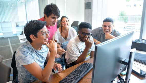Cornell students gathered around computer