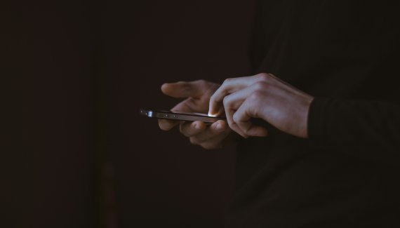 hands holding phone. Photo: Unsplash, Gilles Lambert